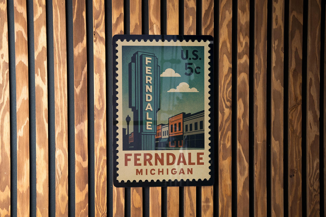 A vintage-style postage stamp from the United States, featuring the name 'Ferndale' and the location 'Michigan', hanging on a wooden wall.