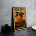 A vintage-style metal stamp depicting an orange and a rural landscape, with the text "TULARE" and "CALIFORNIA" printed on it.