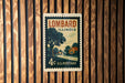 A vintage postage stamp from the United States of America, featuring a rural scene with a road, houses, and trees.