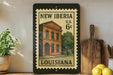 A framed vintage postage stamp depicting a brick building in New Orleans, Louisiana, with the text "NEW IBERIA U.S. 6¢ LOUISIANA".