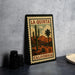 A framed vintage postage stamp from California, featuring a desert landscape with a cactus and mountains, is displayed on a countertop.