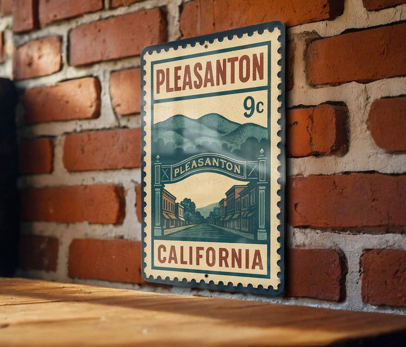 A vintage-style metal sign with the text "PLEASANTON 9c" and "CALIFORNIA" printed on it, mounted on a brick wall.
