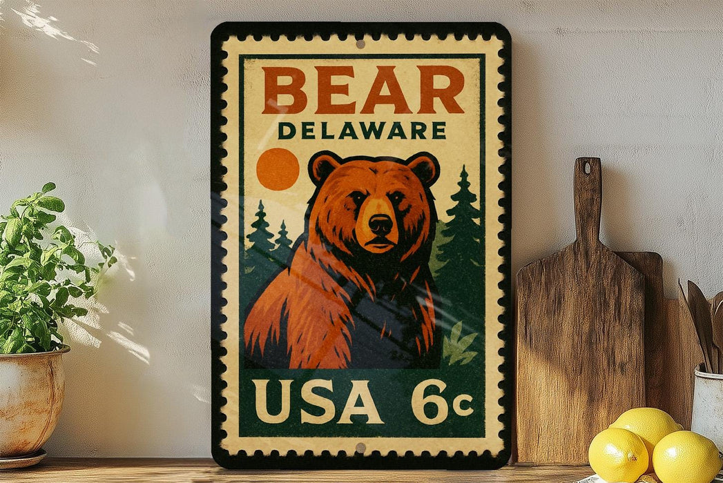 A vintage-style metal stamp featuring a bear on a green background, with the text "BEAR DELAWARE USA 6c" printed on it.