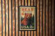 A vintage-style postage stamp featuring a bear on a wooden background, with the text "BEAR DELAWARE" and "USA 6c" printed on it.