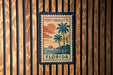 A vintage-style postage stamp from Port Charlotte, Florida, featuring a tropical beach scene with palm trees and a sunset.