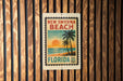 A vintage-style postage stamp from New Myrna Beach, Florida, featuring a palm tree and sunset on the beach.