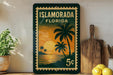 A framed poster of a tropical beach scene with palm trees and a sunset is displayed on a wall, accompanied by a wooden cutting board and a potted plant.