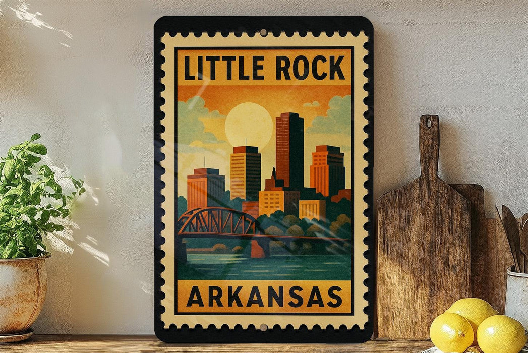 A framed vintage-style poster of Little Rock, Arkansas, featuring a cityscape with a bridge and a sun in the sky.