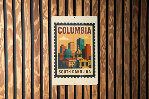 A metal sign with a colorful illustration of a city skyline and the text "COLUMBIA SOUTH CAROLINA" is displayed on a wooden wall.