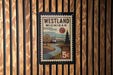 A vintage-style postage stamp from Westland, Michigan, featuring a scenic landscape with a river and a house, mounted on a wooden wall.