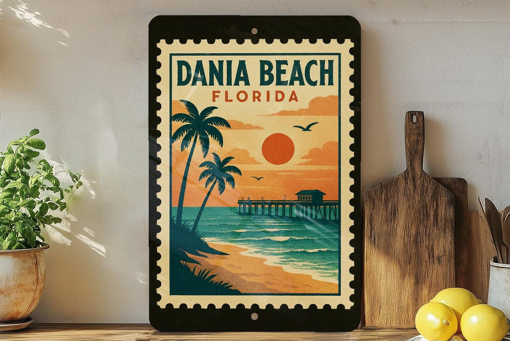A framed poster of a tropical beach scene with palm trees, a pier, and a sunset over the ocean, displayed on a shelf next to a wooden cutting board and a potted plant.