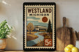 A framed poster of Westland, Michigan, featuring a scenic landscape with a river, trees, and a house.