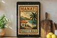A vintage-style sign for Puerto Rico, featuring a tropical landscape with palm trees and a house, is displayed on a shelf next to a wooden cutting board and some lemons.
