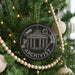 A black ornament with a white text reading "ARCHIVIST" is hanging on a Christmas tree, surrounded by ornaments and lights.