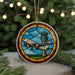 A circular ornament featuring a stained glass-style illustration of an airplane taking off, with a control tower in the background, set against a blurred background of greenery and lights.