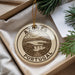 A circular ornament with the text "AZÚRES PORTUGAL" and an illustration of a scenic landscape, hanging from a string.