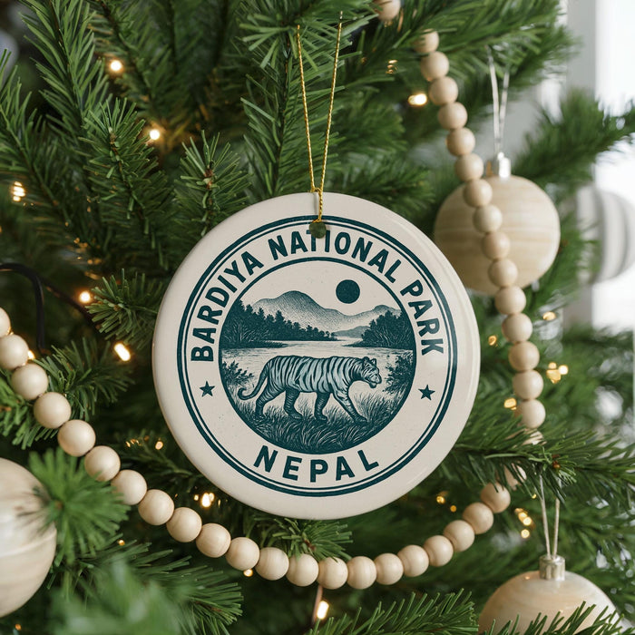 A round ornament on a Christmas tree, featuring a tiger and the text "Bardiya National Park Nepal".