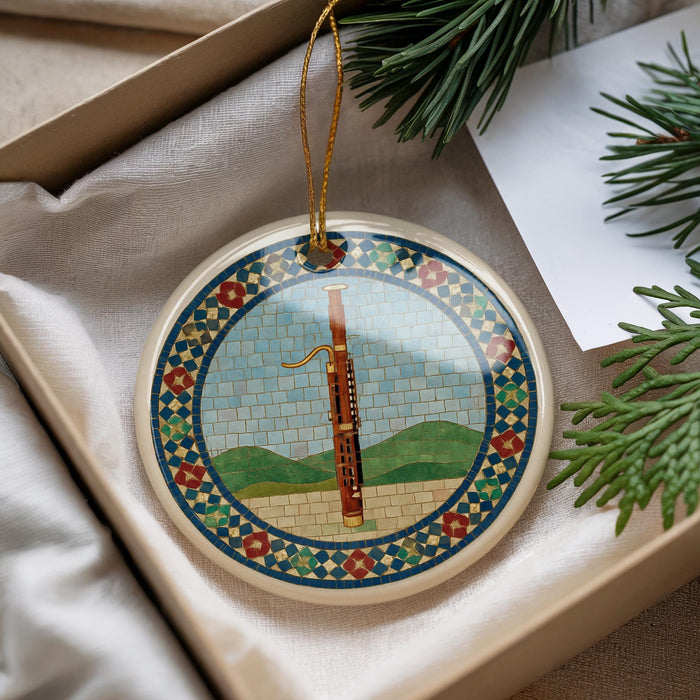 A decorative ornament featuring a musical instrument, specifically a clarinet, is displayed in a box with pine branches and a white card.