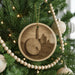 A Christmas tree decorated with ornaments, including a circular ornament featuring a castle and a drum.