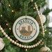 A Christmas tree decorated with ornaments, including a circular ornament with the text "BRASIL" and an illustration of the Christ Cathedral.