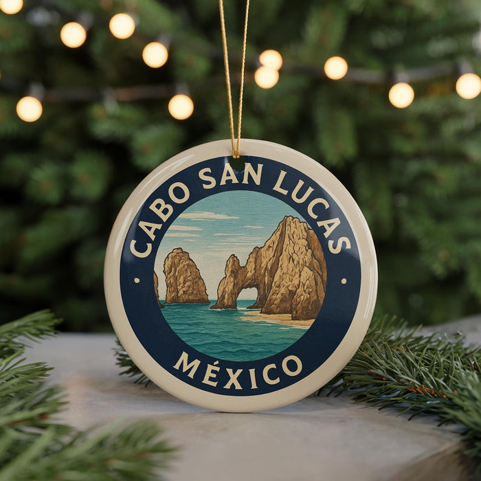 A round ornament with a blue border and a graphic of a coastal landscape, featuring the words "CABO SAN LUCAS MEXICO" in the center.
