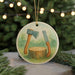 A round ceramic ornament featuring a tree stump with a pair of woodworking tools, such as a saw and a chisel, hanging from a string.