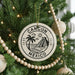 A Christmas tree decorated with ornaments, including a circular ornament with the text "CANCUN MEXICO" and a palm tree design.