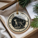 A circular ornament with a dog and stars on it, hanging from a string.