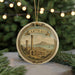 A circular ornament with a decorative border and a painting of a cityscape, featuring the word "Carthago" prominently displayed.