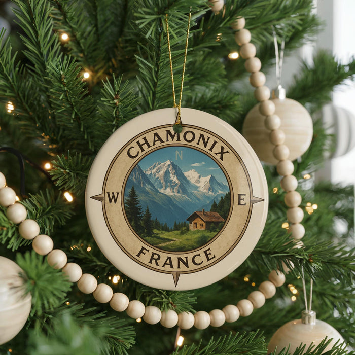 A Christmas tree decorated with ornaments, including a compass ornament with a mountain landscape and the text "CHAMONIX FRANCE" on it.