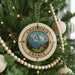 A Christmas tree decorated with ornaments, including a compass ornament with a mountain landscape and the text "CHAMONIX FRANCE" on it.