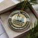 A round ornament with the text "CHEMICAL ENGINEER" and a silhouette of a chemical plant, placed inside a box with pine branches.