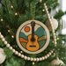 A Christmas tree decorated with a guitar ornament and wooden beads.