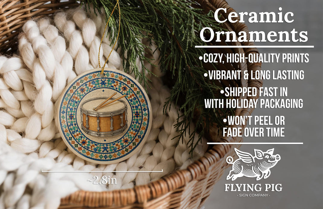 Ceramic ornaments, featuring a drum and a pine branch, are displayed in a woven basket.