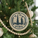 A circular ornament on a Christmas tree, featuring the silhouette of the Burj Khalifa and the text "DUBAI UAE" in a decorative font.