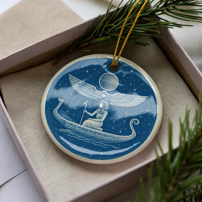 A blue and white ceramic ornament depicting a person in a boat on a starry night, with a winged figure above.
