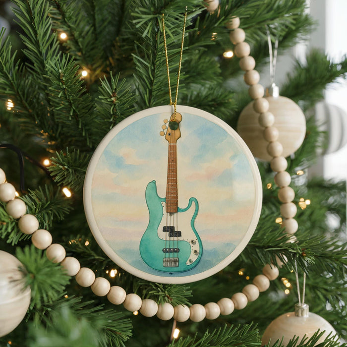 A Christmas tree decorated with ornaments, including a circular ornament featuring a guitar and a string of beads.