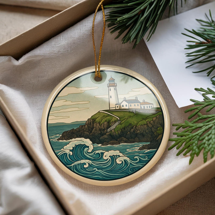 A round ornament featuring a lighthouse on a cliff overlooking the ocean, with waves crashing against the rocks.