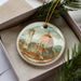 A decorative ornament featuring a painting of the Florence Cathedral, also known as the Cathedral of Saint Mary of the Flower, in the background.