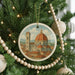 A Christmas tree decorated with ornaments, including a circular ornament featuring the iconic dome of Florence Cathedral, surrounded by a string of beads.
