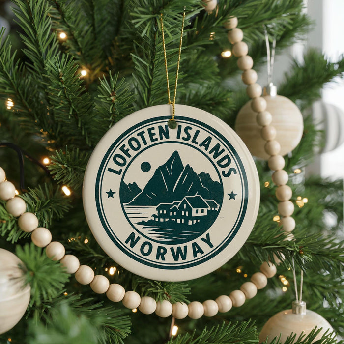 A Christmas tree decorated with ornaments, including a circular ornament with the text "Lofoten Islands NORWAY" and a wooden bead decoration.