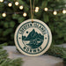 A circular ornament with the text "Lofoten Islands NORWAY" and a mountain silhouette, hanging from a string.