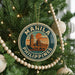 A Christmas tree decorated with ornaments, including a circular ornament with the text "MANILA PHILIPPINES" and a building illustration.