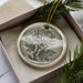A decorative ornament in a box, featuring a chrysanthemum flower design.