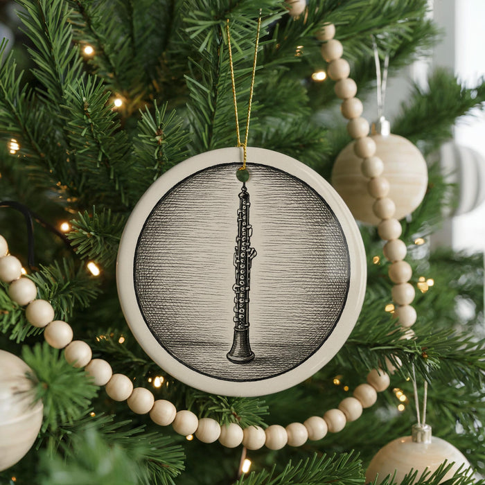 A Christmas tree decorated with ornaments, including a circular ornament featuring a black and white illustration of a clarinet.