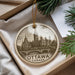 A circular ornament with a drawing of the Canadian Parliament building in Ottawa, Canada, hanging from a string.