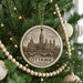 A circular ornament on a Christmas tree, featuring an illustration of the Canadian Parliament building in Ottawa.