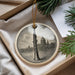 A decorative ornament featuring a tall, slender instrument, possibly a saxophone, is displayed in a box alongside some greenery.