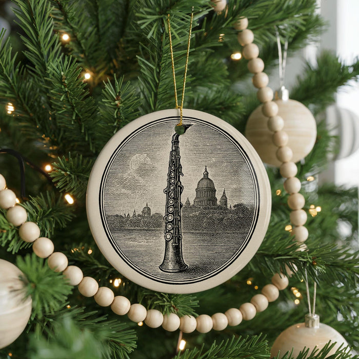 A Christmas tree decorated with ornaments, including a large circular ornament featuring a saxophone and a smaller circular ornament with a ball.