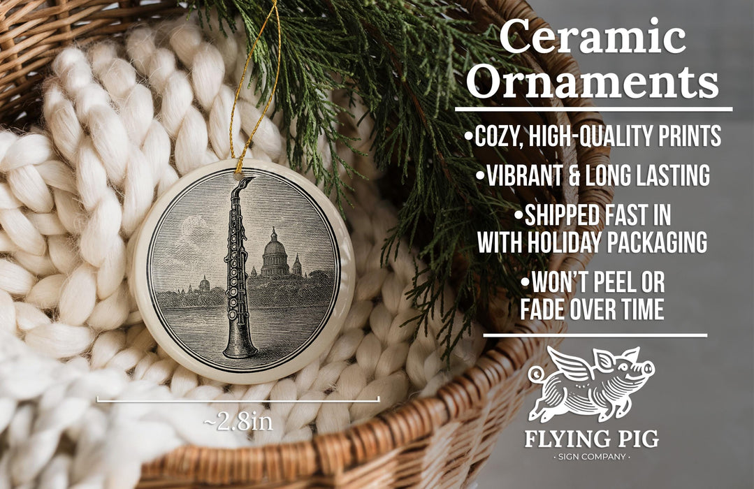 Ceramic ornaments, featuring a detailed image of a saxophone, are displayed in a wicker basket. The text highlights the ornaments as "Ceramic Ornaments" with features such as "Cozy, high-quality prints", "Vibrant & long lasting", "Shipped fast in with holiday packaging", and " Won't peel or fade over time". The image also includes a scale for size comparison and the logo of "Flying Pig - SIGN COMPANY".